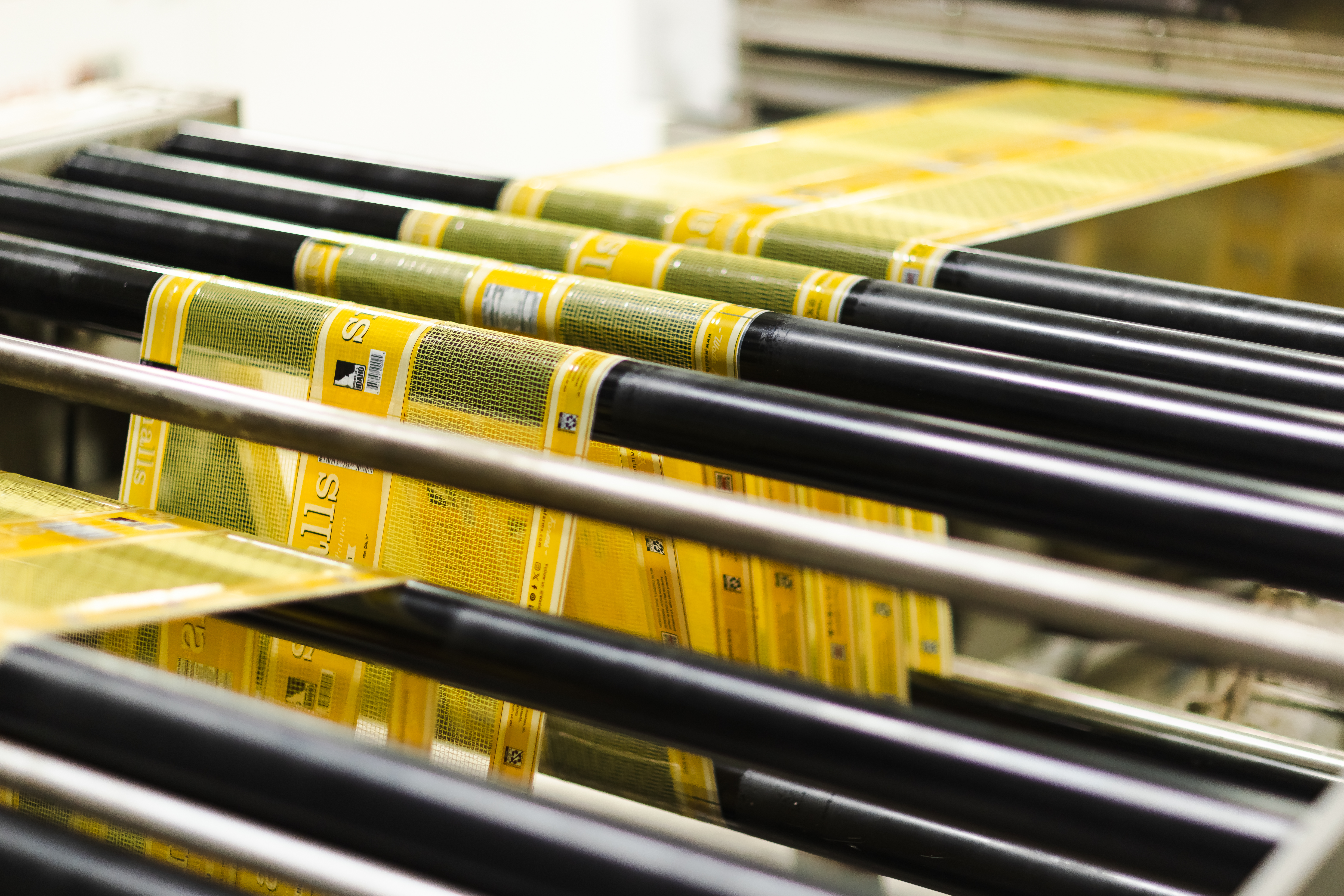Yellow printed ribbon stock running over circular rails on the production line